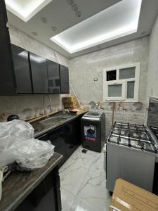 a kitchen with a stove and a sink at بالقرب من مدينتي شقه مميزه جديده ثلاث غرف وحمامين in Badr