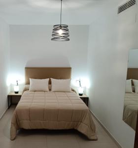 sypialnia z dużym łóżkiem i oświetleniem w obiekcie Vandelvira 2 w mieście Baeza