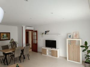 een woonkamer met een eettafel en een televisie bij Vandelvira 2 in Baeza