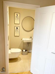 a bathroom with a toilet and a mirror at Character filled Courtyard Escape in Harrogate