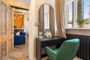 a room with a mirror and a green chair at WhiskAwayStays - Shaw Street - Character city centre apartment in Worcester