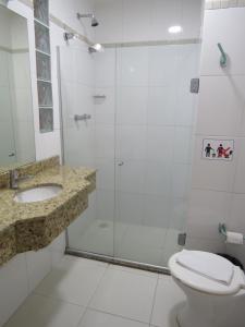 a bathroom with a shower and a toilet and a sink at Adoro Hotel in Farroupilha