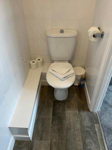 a bathroom with a toilet and two rolls of toilet paper at Cunard Guest House in Weymouth