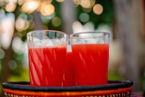 dos vasos de bebida roja en un plato negro en lake mwamba lodge, en Kasenda