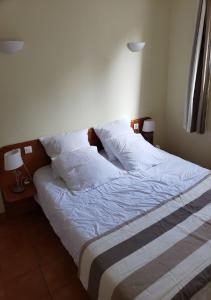 Una cama con sábanas blancas y almohadas en un dormitorio. en RÉSID'AZUR APPARTEMENT T2-PMR- Piscine privée, en Saint-Jean-de-Monts 60 fotos más