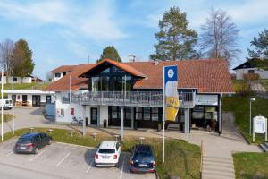 ein Gebäude mit Autos auf einem Parkplatz in der Unterkunft Ferienhaus Nr 3, Typ A, Feriendorf Hochbergle, Allgäu in Bichel