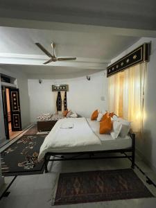 a bedroom with a large bed with orange pillows at Hostel Desert Home Stay in Jaisalmer