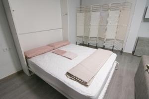 a hospital room with a bed with towels on it at Loft Centro Huelva in Huelva