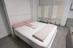 Una habitación de hospital con una cama con toallas. en Loft Centro Huelva, en Huelva