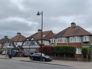 un coche negro estacionado frente a una fila de casas en Beddington Park Lodge West en Wallington