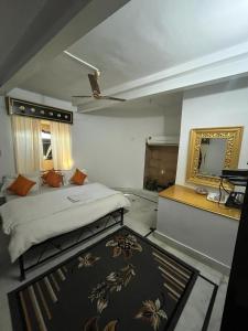 1 dormitorio con cama, espejo y alfombra en Hostel Desert Home Stay, en Jaisalmer