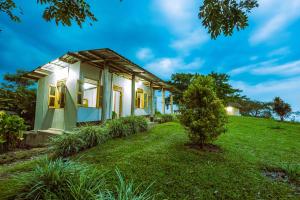 ein Haus auf einem Hügel mit einem grünen Hof in der Unterkunft lake mwamba lodge in Kasenda