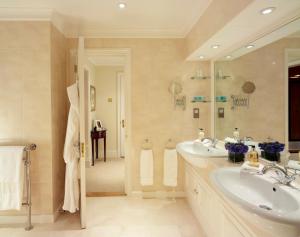 uma casa de banho com 2 lavatórios e um espelho grande em Cheval Hyde Park Gate em Londres