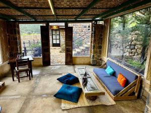 a living room with a blue couch and a table at Blue Jay Valley in Jezzîne