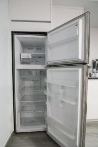 Un refrigerador vacío con la puerta abierta en una cocina. en Loft Centro Huelva, en Huelva
