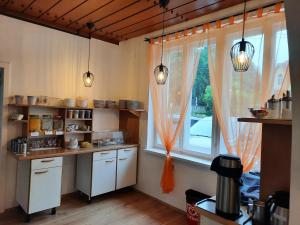 a kitchen with a window and white cabinets and a table at Pension Horvath in Sankt Kanzian