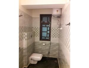 baño con aseo y ventana en Hotel Lasso Regency & Spa, Namchi, en Namchi