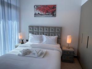 um quarto com uma grande cama branca e 2 toalhas em Gennaro´s home at 15 Northside Business Bay em Dubai
