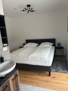 a bedroom with a bed with a ceiling fan and a sink at Aparthotel Umbrella in Vienna