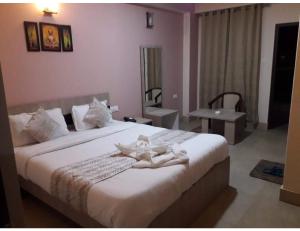 1 dormitorio con 1 cama grande y toallas blancas. en Hotel Lasso Regency & Spa, Namchi, en Namchi