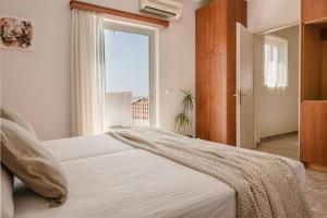 a bedroom with a large white bed with a window at Villa Marita in Spathíon +30 photos