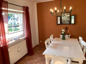 a dining room with a white table and a window at Gemütliches Haus - traumhafter großer Garten 