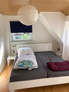 un letto in una piccola stanza con una grande finestra di Gemütliches Haus - traumhafter großer Garten 
