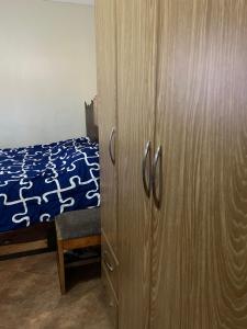 1 dormitorio con armario de madera y cama en MD comfort homes, en Kampala