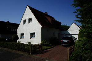 una casa bianca con una macchina parcheggiata di fronte di Gemütliches Haus - traumhafter großer Garten 