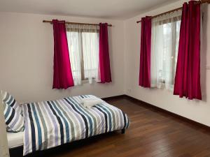 1 dormitorio pequeño con cortinas rojas y 1 cama en Maison Le Perreux sur marne 4 chambres, en Le Perreux-Sur-Marne