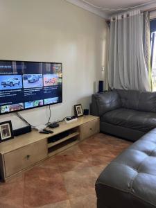 sala de estar con sofá y TV de pantalla plana en MD comfort homes, en Kampala