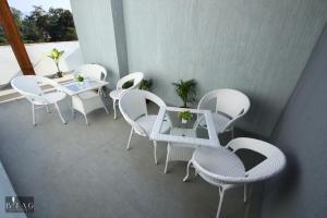 een groep witte stoelen en tafels op een balkon bij NDBL Exotica INN Haridwar in Haridwār