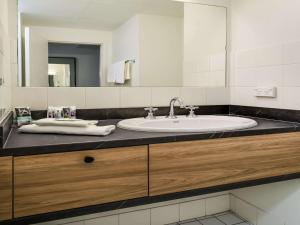 ein Bad mit einem Waschbecken und einem Spiegel in der Unterkunft Mercure Albury in Albury