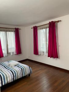 a bedroom with red curtains and a bed and wooden floors at Maison Le Perreux sur marne 4 chambres in Le Perreux-Sur-Marne