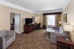 a hotel room with a couch and a desk at La Quinta by Wyndham Houma in Houma