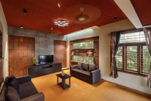 uma sala de estar com um sofá e uma televisão em Zenith Edge Villa by JadeCaps 3BHK Duplex Wifi em Bangalore