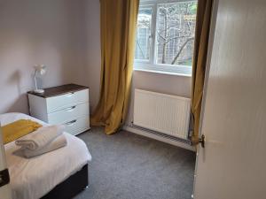 1 dormitorio con 1 cama con tocador y ventana en RentUnique The Sissinghurst en Three Bridges
