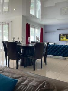 comedor con mesa negra y sillas en Maison Le Perreux sur marne 4 chambres, en Le Perreux-Sur-Marne