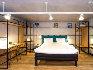 a bedroom with a bed and a desk and shelves at ibis Porto Centro Mercado Bolhao in Porto