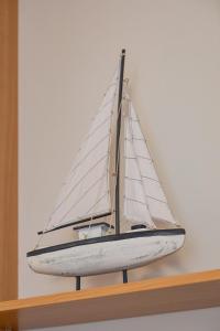 a model of a sailboat sitting on a shelf at Charming Apartment Located near the Promenade in Świnoujście by Renters in Świnoujście