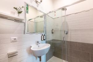 biała łazienka z umywalką i prysznicem w obiekcie Colosseo Road w Rzymie