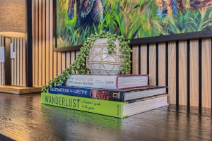 a stack of books on a table with a vase on top at Helling Circle Secret 102 condo in Heber City