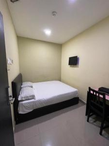 1 dormitorio con 1 cama y TV en la pared en Hotel Global Subang, en Subang Jaya