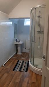 uma casa de banho com um chuveiro e um lavatório. em One Bedroom Flat with on premises parking em Walsall