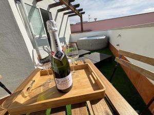 una bottiglia di vino seduta su un tavolo con bicchieri da vino di Villa Buenavistas ad Adeje