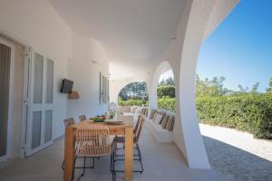 una sala da pranzo con tavolo, sedie e divano di Villa con Piscina Dimora Egnazia a Monopoli