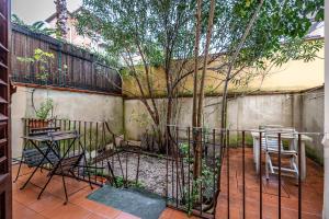 een patio met een boom en stoelen en een hek bij Appartamento Con Giardino in Florence