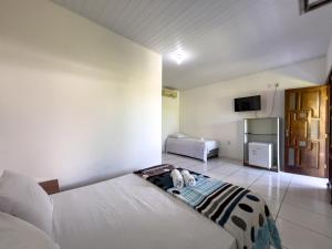 a bedroom with a bed and a tv in it at Pousada Praia da Cueira in Cayru
