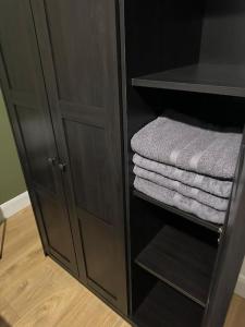 a black cabinet with some towels in it at Convenient & Central Apartment in Dublin