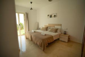 Un dormitorio con una cama y una ventana grande. en Sunstay House Sol Andalusi Alhaurin, en Alhaurín de la Torre